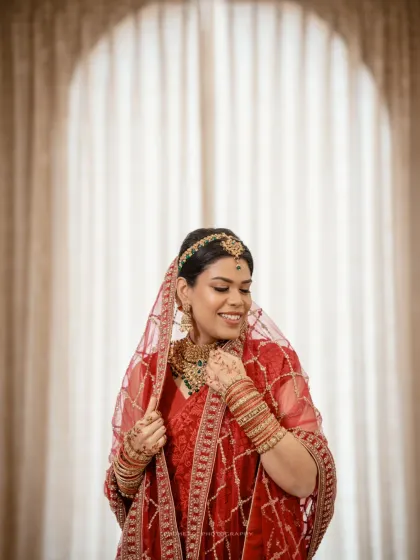 A stunning portrait of the Nikah bride in her traditional red attire, her happiness radiating.