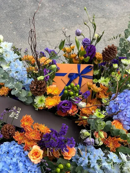 Do you want to give gifts that are almost too good to open? I dress special presents with matching flowers, like this arrangement of blue hydrangeas and orange chrysanthemums designed to complement the gift box.