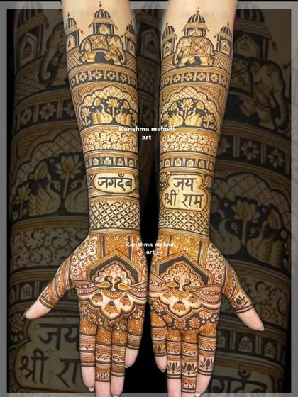 A spiritual and traditional bridal design featuring "Jai Shri Ram" and "Jagdev" written in elegant Devanagari script. The arms are adorned with temple architecture and other sacred motifs, reflecting the couple's faith.