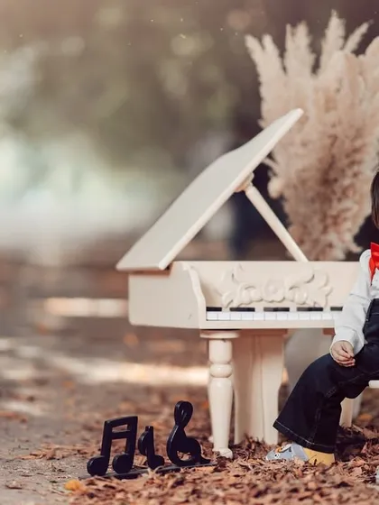A thoughtful little musician in a beautiful autumn setting. The red bowtie adds a pop of color to this charming and classic portrait.