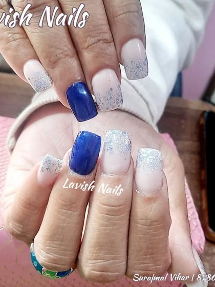 A cool-toned set with light pink, royal blue, and silver glitter fade nails.