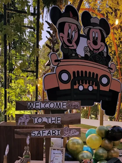 A welcome station featuring a large cutout of Mickey and Minnie Mouse in a safari jeep. This serves as a fantastic photo opportunity for guests as they enter the party.
