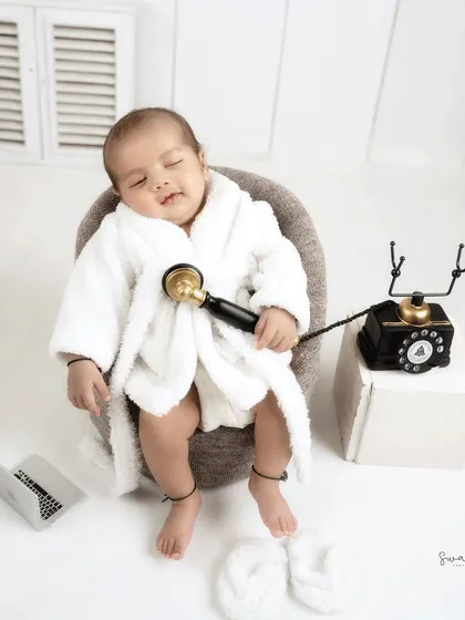 Even a boss baby needs to take calls. Here he is, sleeping with a vintage telephone receiver, with a tiny laptop nearby.