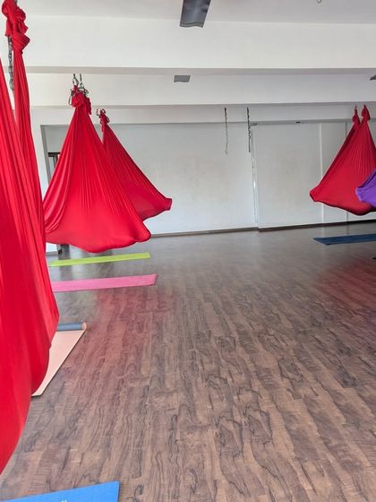 The empty studio, with colorful aerial silks hanging ready for class. A space of potential and peace.