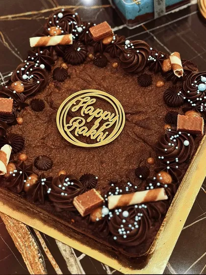 A rich chocolate brownie cake with a "Happy Rakhi" topper. It's a decadent treat perfect for celebrating with your sibling.