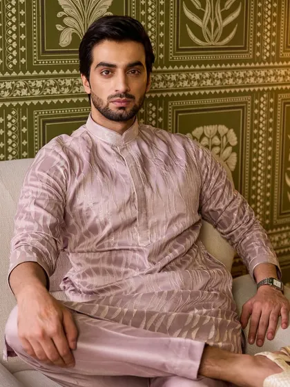A seated portrait that allows a closer look at the fabric's texture and the rich, understated color of this unique kurta set.