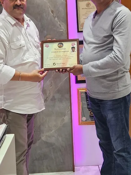 Presenting a certificate of completion to a participant at the end of a successful numerology workshop.