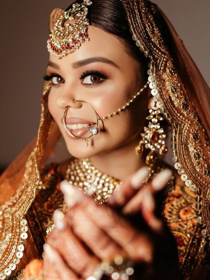 A stunning close-up of the bride, her expressive eyes and traditional nath (nose ring) being the focal point of this captivating shot.