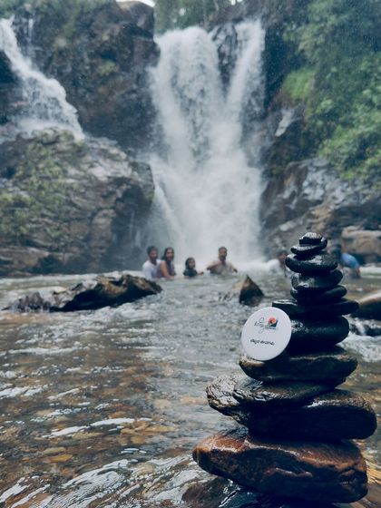 A creative shot of our trek badge on a stack of balanced stones in a stream near Gangadikal.