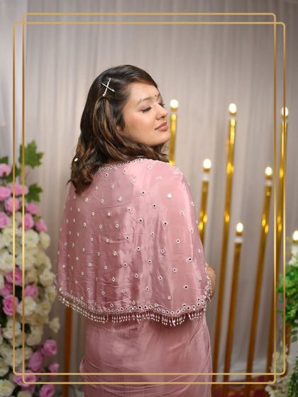 A closer look at the back of the pink draped saree gown, highlighting the delicate mirror work on the cape.