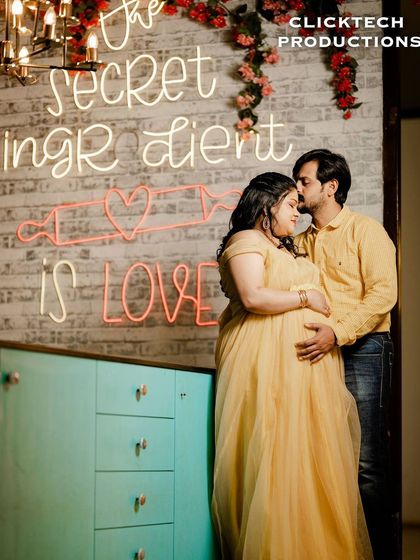 A sweet and intimate maternity moment in our colorful kitchen set, under the 'The secret ingredient is love' neon sign.