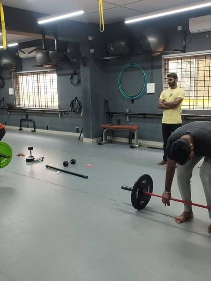 A female student performs a deadlift with proper form, demonstrating that strength training is for everyone. Our trainers ensure each student masters the technique.