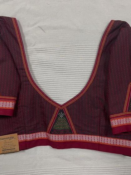 This deep maroon blouse in Ilkal cotton features a deep V-neck and is embellished with traditional 'gopura' motifs using Negi and Kasuti embroidery.