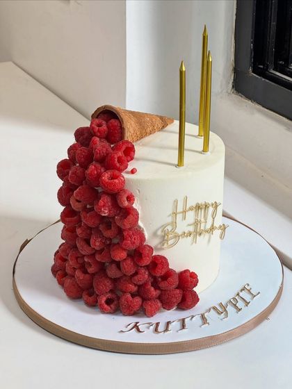When elegance meets indulgence. This modern cake design features fresh raspberries cascading from a cone, complemented by clean lines and golden details for an unforgettable birthday moment.