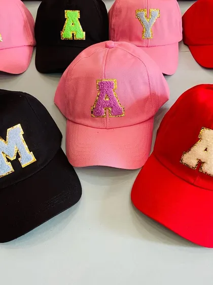 A collection of our personalized initial caps, highlighting the different color combinations available for both the caps and the chenille patches.
