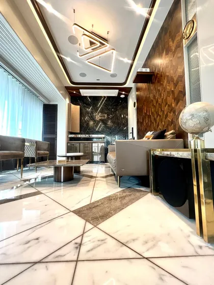 The secret to a unique space is in the details. This low-angle shot highlights the intricate geometric patterns in the marble floor, the rich wood-paneled wall, and the modern triangular light fixture.
