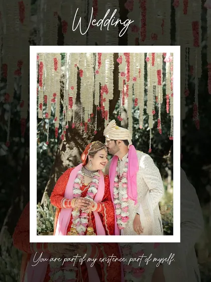 A tender moment as the groom kisses the bride's forehead under a beautiful floral canopy.