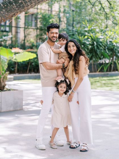 A beautiful, classic family portrait on a wooden walkway. Everyone is looking at the camera, but the feeling is still relaxed and natural.