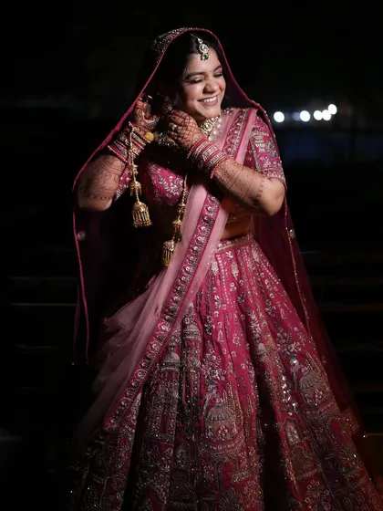 A candid shot of the bride adjusting her earrings, her smile lighting up the frame.