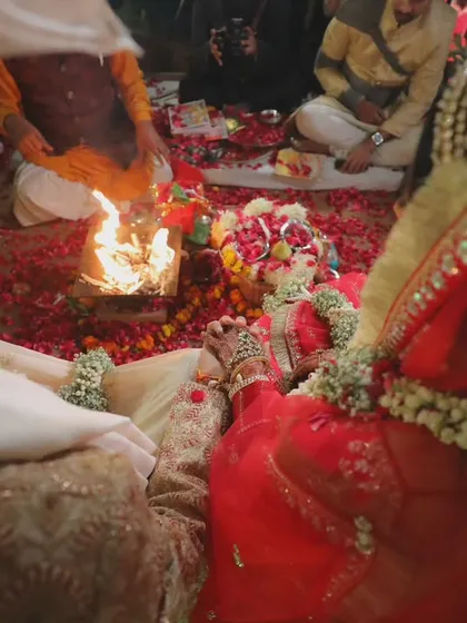 An overhead shot of the couple during the pheras, circling the sacred fire. This perspective highlights the central ritual of a Hindu wedding ceremony.