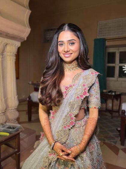 An elegant open hairstyle with a center part and soft waves for an engagement ceremony. This is a timeless look that suits any occasion.