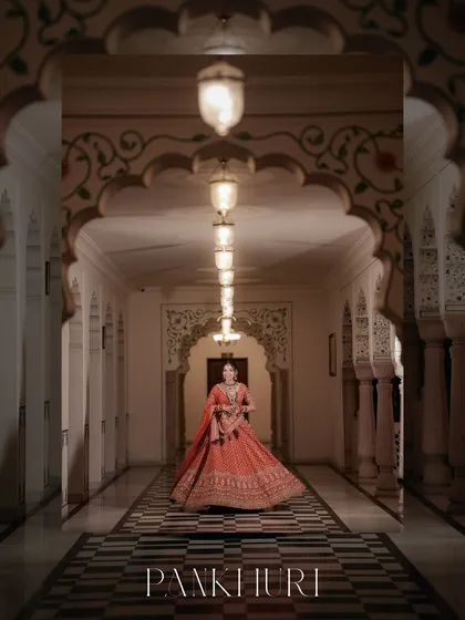 A bride, poised and radiant, in a majestic palace corridor. We specialize in creating these artistic, cinematic bridal portraits that feel like a scene from a royal epic, celebrating the grace and beauty of the moment.