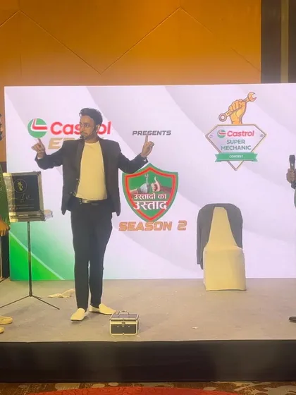 A dynamic moment on stage during a Castrol corporate event, involving two volunteers in an illusion.