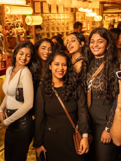 A group of friends smiling for the camera, enjoying the classic tunes and great company.