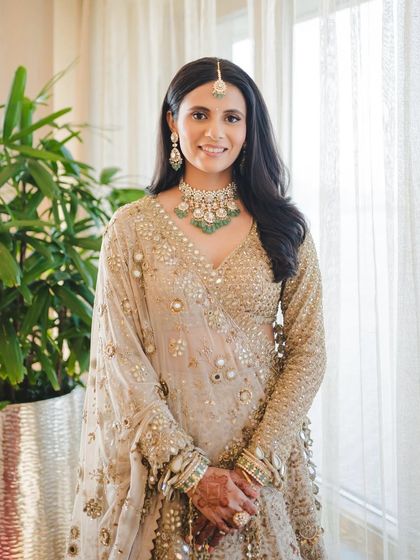 This shot showcases the full look, where the makeup perfectly complements the mirror-work lehenga and emerald jewelry without being overpowering.