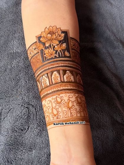 A beautiful lotus-themed band for the forearm. The use of negative space and detailed shading makes the lotus flowers pop, creating a modern yet traditional look.