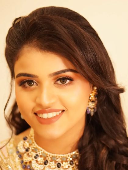 A bright, happy portrait of Payal. Her reception makeup, featuring sparkling eyes and a warm smile, is the perfect complement to her joyful demeanor.