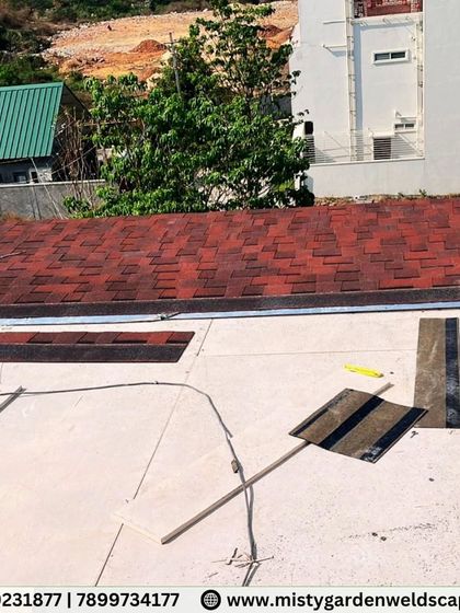 Work in progress on a shingles pergola on Bannerghatta Road. This image shows the layering process of the shingles over the roof base, a crucial step for ensuring a waterproof and long-lasting finish.