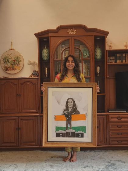 A proud moment for my client, a national powerlifter, holding her custom portrait. The piece combines two photos and incorporates the Indian flag, which I drew with colored pencils.