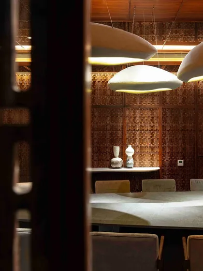 A glimpse into the dining room through the Pinjirakari lattice work. This detail shows how we use traditional crafts to filter light and create atmosphere.