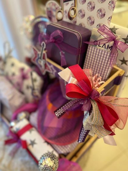 The vibrant purple and pink color scheme of the popstar hamper, with custom-wrapped gifts and musical note accents.