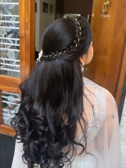 A beautiful half-up, half-down hairstyle with a braided crown and soft curls.