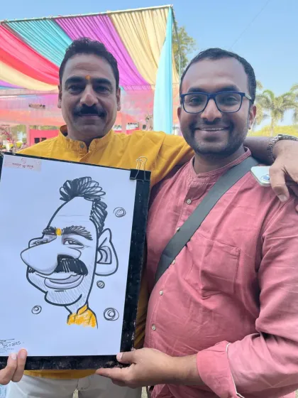 Here I am with a happy guest and his caricature. It's always great to connect with people and share a laugh during the drawing process.