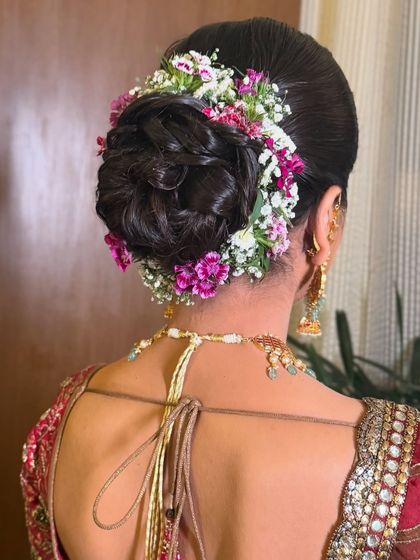 A classic bridal updo featuring a mix of purple and white flowers, creating a beautiful texture and color palette.