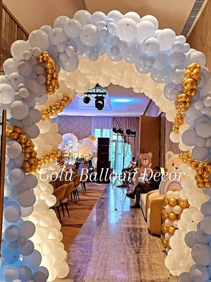 A stunning blue, white, and gold balloon arch creating a beautiful entrance for the teddy bear themed party.