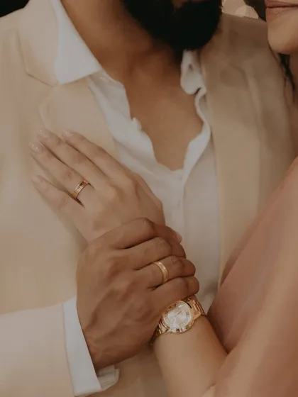 An intimate detail shot focusing on the couple's hands and rings, symbolizing their new commitment.