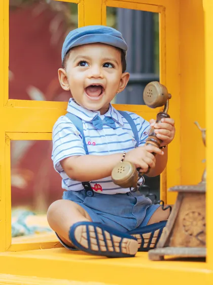 A burst of pure joy! This baby boy's ecstatic expression while holding a vintage telephone receiver is absolutely priceless.