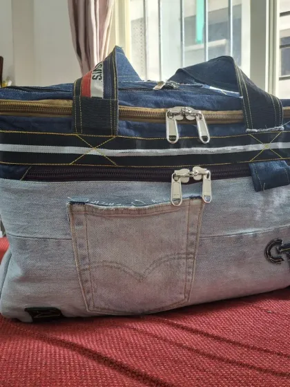 This spacious travel bag was crafted entirely from old pairs of Levi's jeans. It shows how we can transform durable, used material into a large, functional, and stylish new product.