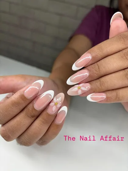I love putting a creative spin on a classic. This is a timeless French manicure on almond extensions, elevated with delicate, hand-painted white daisies on the accent nails for a touch of spring.