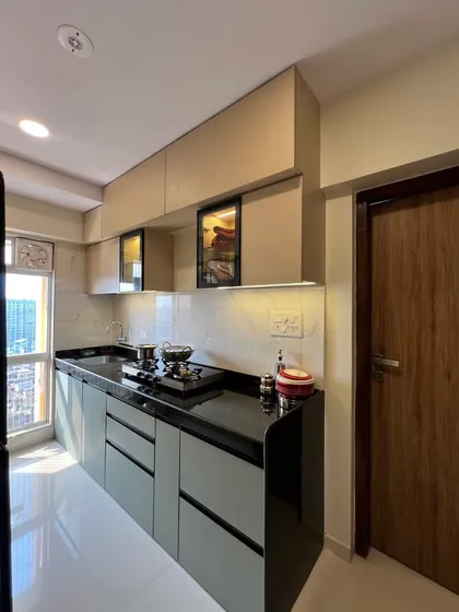 This view shows the clean lines of the handleless cabinets and the built-in hob, contributing to the kitchen's modern aesthetic.