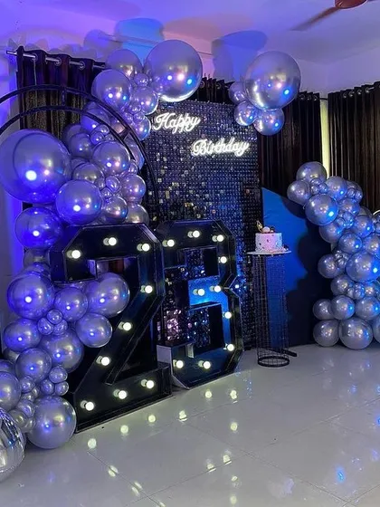 Celebrating a milestone birthday calls for something stylish. This 23rd birthday setup features a modern silver and black theme with large marquee numbers, a shimmering sequin backdrop, and stunning chrome silver balloons for a cool, club-like vibe.