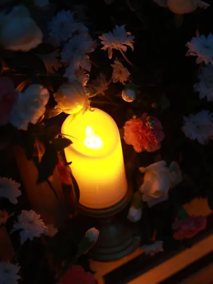The warm glow of a single candle nestled among fresh flowers. It's small details like this that help create a deeply romantic atmosphere for your special occasion.