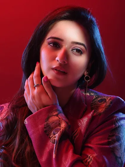 This pose adds a touch of elegance and thoughtfulness. The interaction between her hand and face creates a classic portrait composition, elevated by the modern, colorful lighting.