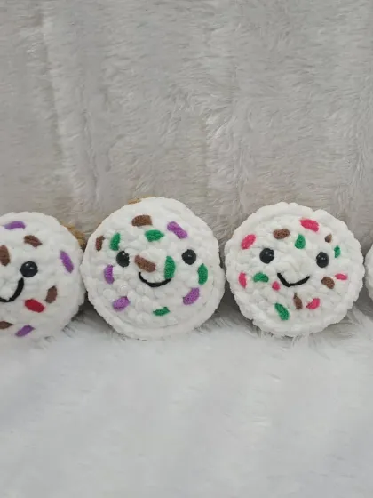 A row of vanilla plush cupcakes with rainbow sprinkles.