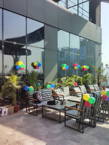 Simple, colorful balloon bunches placed strategically across this modern rooftop terrace add a festive touch without obstructing the view or walkways.