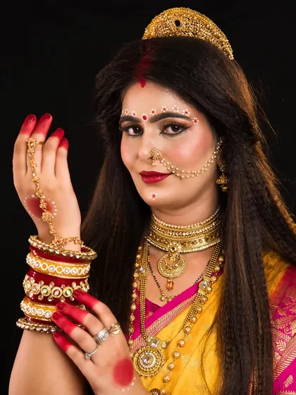 A depiction of Skandmata, the fifth form of Durga, with traditional Bengali-style makeup elements.